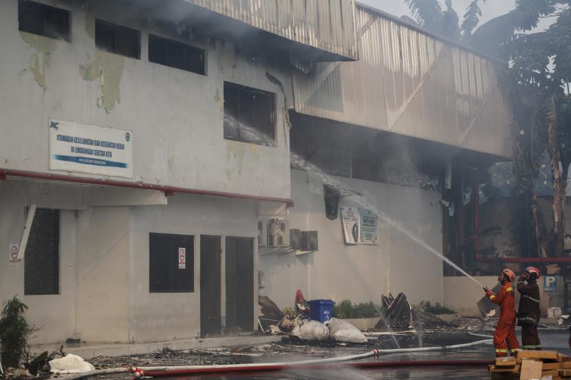Petugas pemadam kebakaran menyemprotkan air guna memadamkan api di Gudang JNE, Jalan Pekapuran, Kecamatan Cimanggis, Kota Depok, Jawa Barat, Senin (12/9/2022).