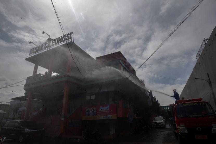 Petugas Pemadam Kebakaran menyemprotkan cairan disinfektan di area Pasar Cileungsi, Kabupaten Bogor, Jawa Barat. Kabupaten Bogor memperpanjang PSBB hingga 18 Juni 2020.