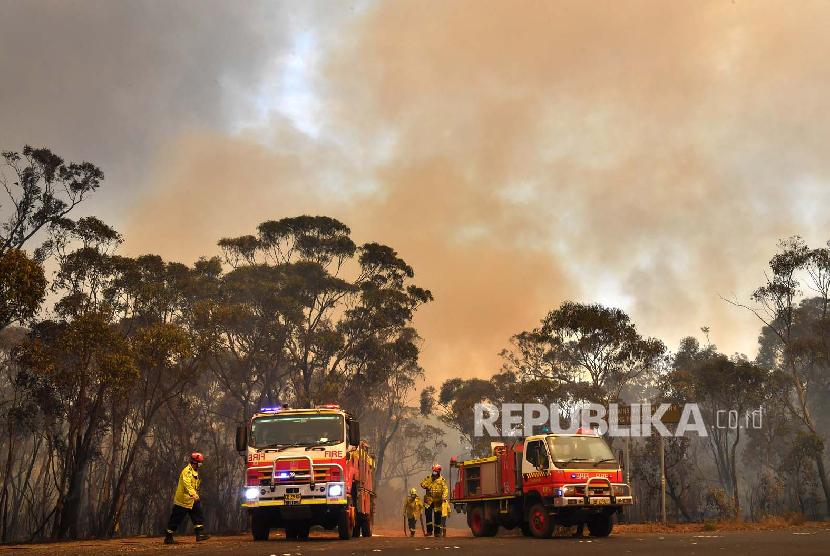 Petugas pemadam kebakaran New South Wales berupaya memadamkan api di Blue Mountains National Park, barat laut Sydney, Australia. Kemeriahan tahun baru kali ini dibayangi berbagai masalah mulai dari kebakaran hutan dan unjuk rasa. Ilustrasi.