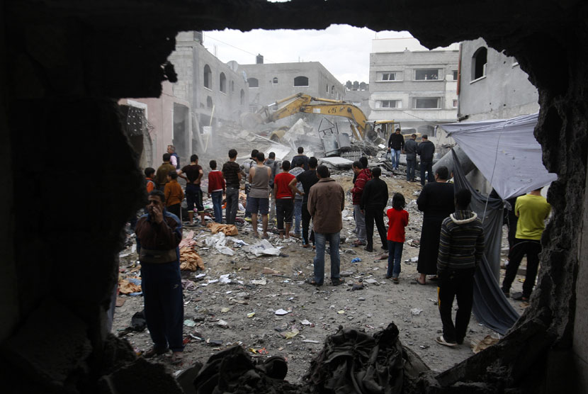 Petugas pemadam kebakaran Palestina mencari korban yang tertimpa reruntuhan bangunan akibat serangan udara Israel di kamp pengungsi Jebaliya sebelah Utara Jalur Gaza, Sabtu (17/11).  (AP/Hatem Moussa)