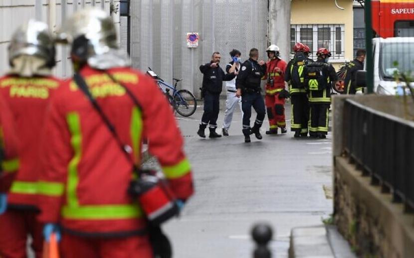 Petugas pemadam kebakaran Prancis memindahkan orang yang terluka ke ambulans yang menunggu di dekat bekas kantor majalah satir Prancis Charlie Hebdo menyusul dugaan serangan oleh seorang pria yang memegang pisau di Paris pada 25 September 2020 