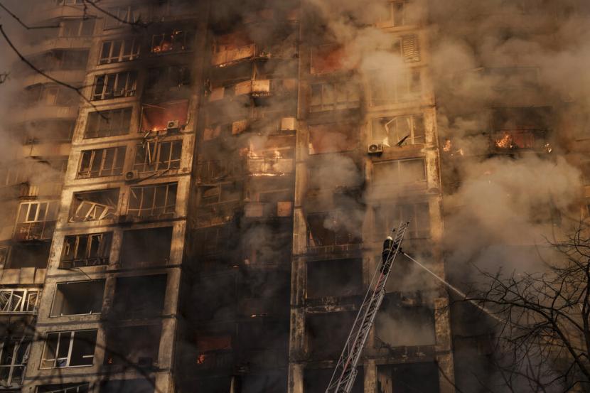 Petugas pemadam kebakaran Ukraina bekerja di sebuah gedung apartemen yang dibom di Kyiv, Ukraina, Selasa, 15 Maret 2022.