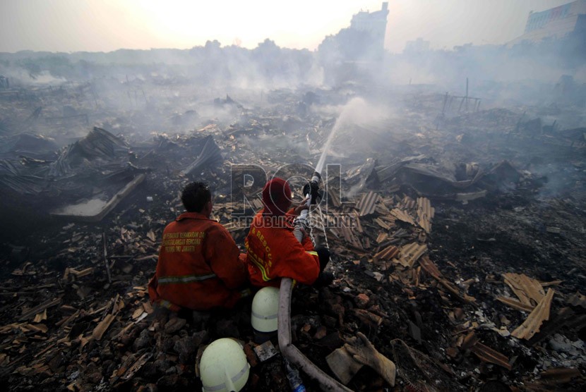 Petugas pemadam memadamkan sisa bara api kebakaran yang melanda pemukiman di RT 07, RW 13 Kelapa Gading, Jakarta Utara, Selasa (1/10).   (Republika/ Wihdan)