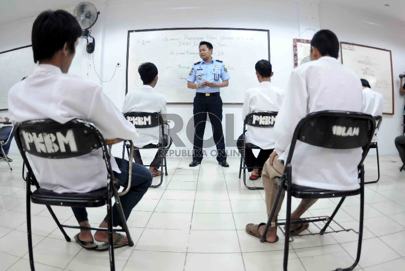  Petugas pembina kemasyarakatan memberi arahan sebelum Ujian Nasional pendidikan kesetaraan melalui program kejar paket C yang diikuti oleh warga binaan di Lembaga Pemasyarakatan Cipinang, Jakarta Timur, Senin (13/4).  (Republika/Agung Supriyanto)