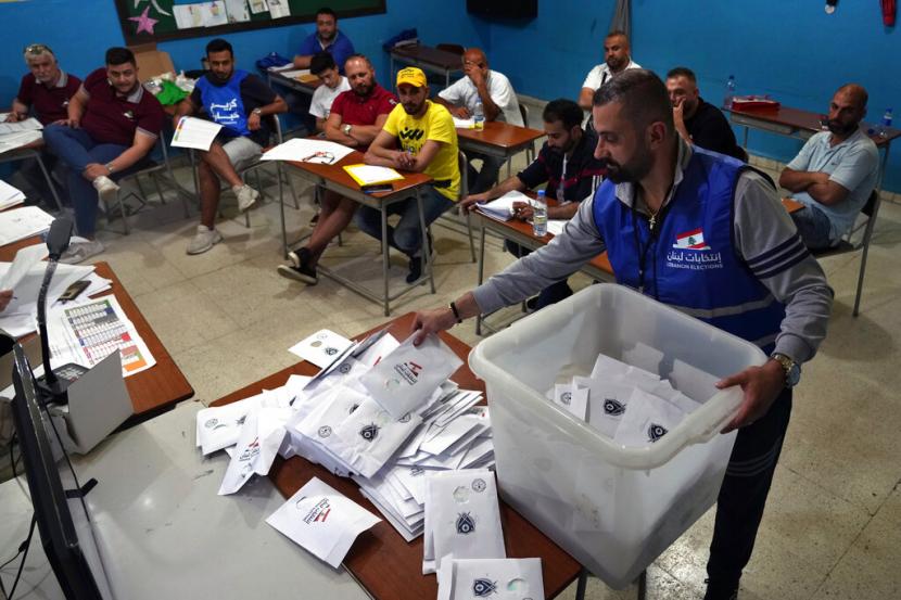 Petugas pemilu menghitung surat suara tak lama setelah tempat pemungutan suara ditutup, di kota utara Tripoli, Lebanon, Minggu, 15 Mei 2022. Warga Lebanon memilih parlemen baru hari Minggu dengan latar belakang krisis ekonomi yang mengubah negara dan rendahnya ekspektasi bahwa pemilu akan secara signifikan mengubah lanskap politik.