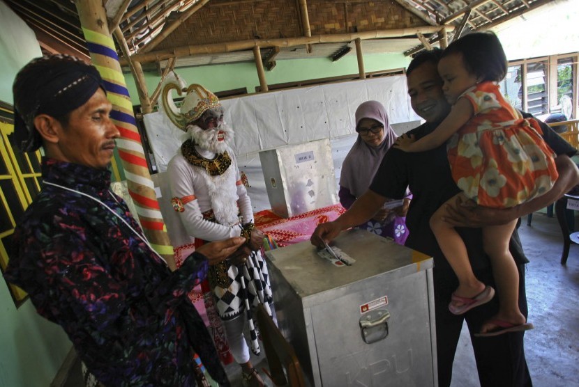 Petugas Pemungutan Suara berkostum tokoh wayang Hanoman melayani warga yang menggunakan hak suaranya pada Pilkada Bantul 2015 di TPS 17 Sulang Kidul, Patalan, Jetis Bantul, DI Yogyakarta, Rabu (9/12). 
