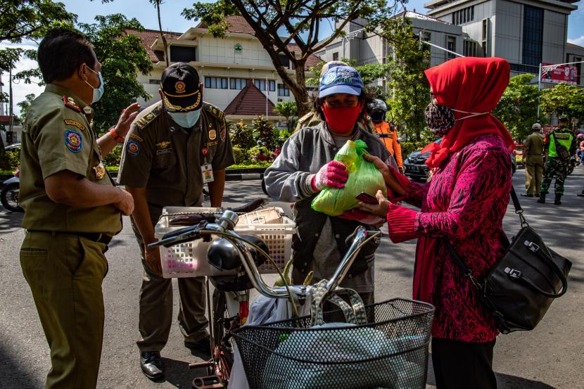 Petugas penegak protokol kesehatan Kota Semarang memberikan sembako gratis kepada warga yang mematuhi protokol kesehatan saat Operasi Yustisi Protokol COVID-19 di Semarang, Jawa Tengah