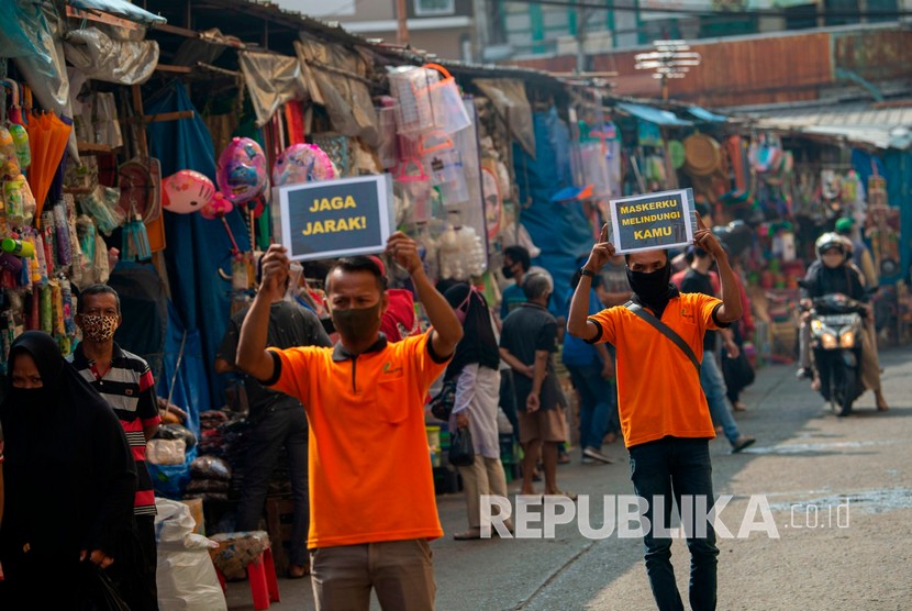 Petugas pengelola pasar berkampanye pencegahan COVID-19 dengan membawa poster berisi pesan di Pasar Jatinegara, Jakarta, Kamis (11/6/2020). Upaya tersebut untuk meminimalisir kasus penularan atau penyebaran COVID-19 terjadi di pasar. 