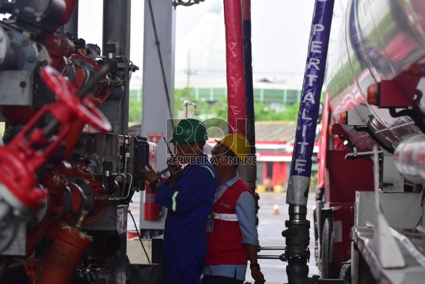 Petugas pengisian bahan bakar di mengisikan BBM jenis Pertalite ke Truk Tangki bahan bakar di Terminal BBM Surabaya Group Pertamina, Surabaya, Selasa (10/11).