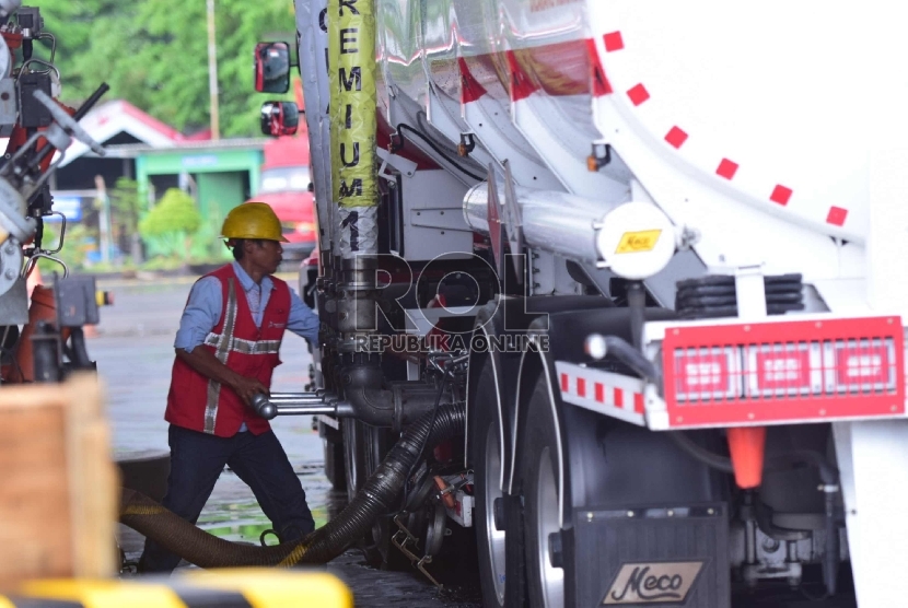 Petugas pengisian bahan bakar mengisikan BBM ke Truk Tangki bahan bakar di Terminal BBM Surabaya Group Pertamina, Surabaya, Selasa (10/11). 