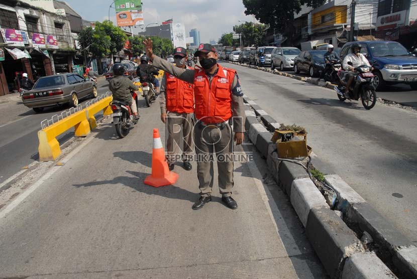   Petugas penjaga jalur busway menghalau sejumlah pengendara kendaraan bermotor yang hendak melintasi jalur busway di jalan Warung Buncit, Jakarta Selatan, Rabu (28/11).  (Republika/Agung Fatma Putra)