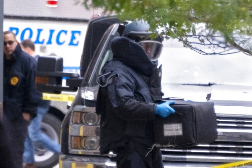 Petugas penjinak bom NYPD membawa paket mencurigakan yang ditemukan di kantor pos di pusat kota Manhattan, Jumat (26/10) waktu AS. Seorang pria di Florida sudah ditahan pascainsiden pengiriman bom pipa ke tokoh penting Partai Demokrat.