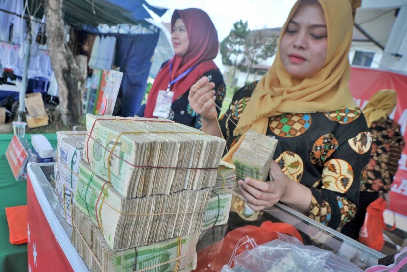 Petugas penukaran uang menyusun pecahan kertas uang Riyal di salah satu stan penukaran uang di Asrama Haji Palembang, Sumsel, Jumat (20/7). 
