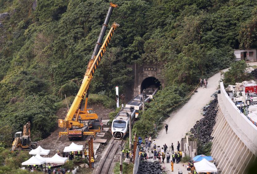 Petugas penyelamat memindahkan sebagian dari kereta yang tergelincir di dekat Ngarai Taroko di Hualien, Taiwan pada hari Sabtu, 3 April 2021.