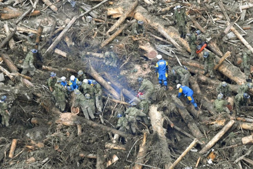 Petugas penyelamat mencari warga yang hilang akibat hujan lebat di desa Toho, prefektur Fukuoka, selatan Jepang, Sabtu, 8 Juli 2017.