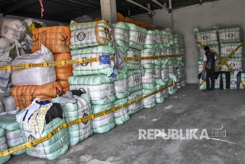 Petugas Perlindungan Konsumen dan Tertib Niaga (PKTN) Kementerian Perdagangan memeriksa barang bukti berupa pakaian bekas impor ilegal yang disita di gudang kawasan Gedebage, Kota Bandung.