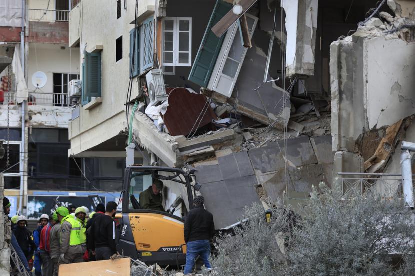 Petugas pertahanan dan penyelamat sipil membersihkan puing-puing dari sebuah bangunan yang diserang Rabu malam oleh serangan udara Israel, di kota Nabatiyeh, Lebanon selatan, Kamis, 15 Februari 2024. 