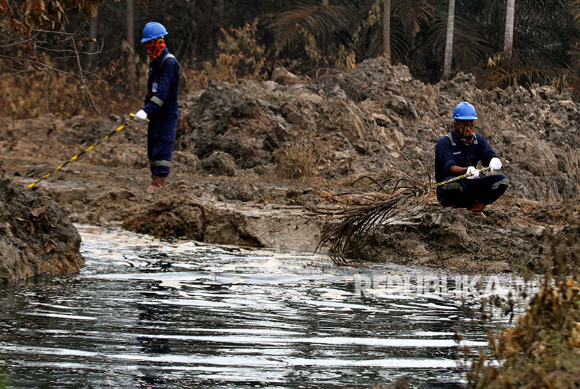 Petugas Pertamina mengawasi saluran pembuangan cairan minyak (Lesser) dari lubang ledakan sumur minyak illegal warga di Desa Pasir Putih, Ranto Panjang Peureulak, Kabupaten Aceh Timur, Kamis (26/4). 