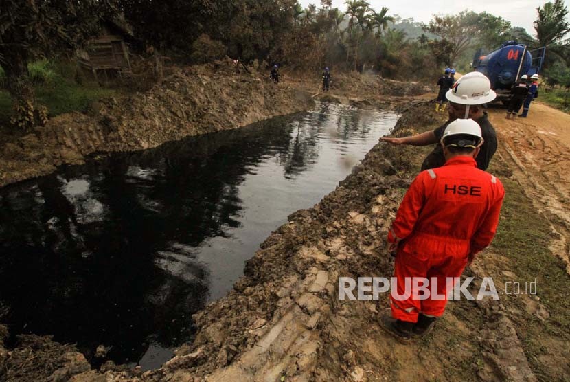 Petugas Pertamina mengawasi saluran pembuangan cairan minyak (Lesser) yang dialirkan dari lubang ledakan sumur minyak illegal warga di Desa Pasir Putih, Ranto Panjang Peureulak, Aceh Timur, Kamis (26/4).