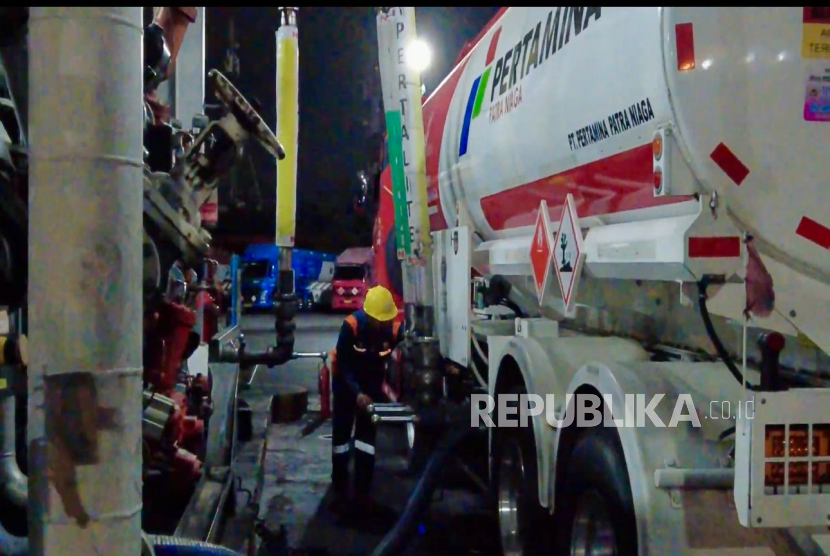 Petugas Pertamina sedang melakukan pengisian BBM