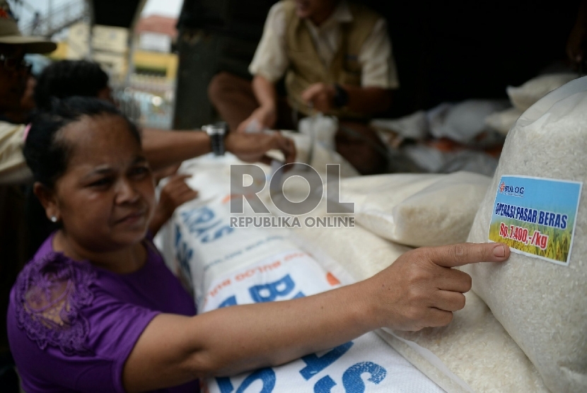 Petugas Perum Badan Urusan Logistik (Bulog) melayani warga yang membeli beras bulog saat digelarnya oprasi pasar beras dikawasan Pasar Jatinegara, Jakarta, Rabu (18/2).