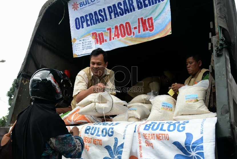 Petugas Perum Badan Urusan Logistik (Bulog) melayani warga yang membeli beras bulog saat digelarnya oprasi pasar beras dikawasan Pasar Jatinegara, Jakarta, Rabu (18/2).