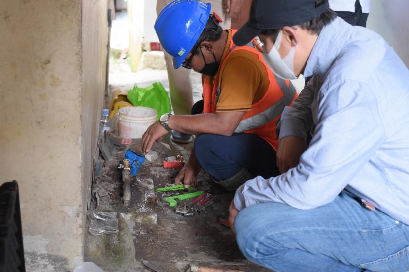 Petugas Perumda Air Minum Tirta Bumi mengecek jaringan air bersih ke rumah warga.