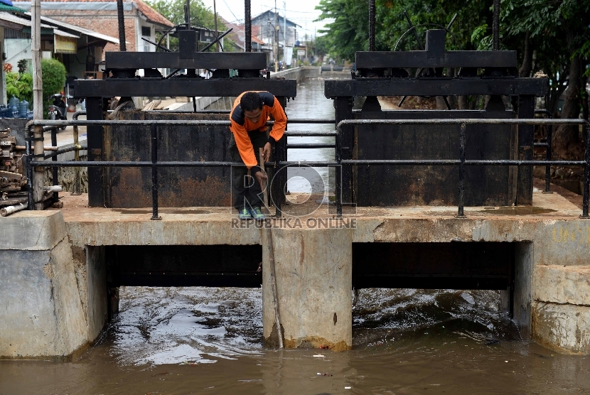  Petugas pintu air melakukan pembersihan di Pintu Air Hek Kramatjati, Jakarta Timur, Selasa (17/11). 