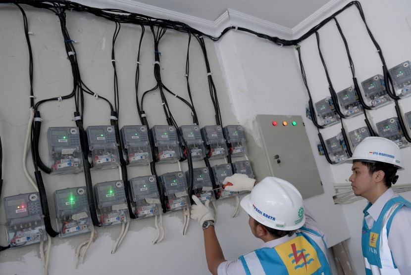 Petugas PLN Area Bulungan Distribusi Jakarta Raya melakukan penyambungan penambahan daya pelanggan 1300 VA menjadi 2200 VA di kawasan Kebayoran Lama, Jakarta Selatan, Selasa (20/6). 