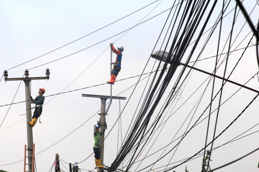 Petugas PLN melakukan perbaikan jaringan listrik di jalan raya Sukaraja, Kabupaten Bogor, Jawa Barat, Rabu (22/6/2022). Pemerintah menaikkan tarif listrik untuk periode Juli-September 2022, pelanggan yang mengalami penyesuaian tarif yakni pelanggan rumah tangga 3.500 VA ke atas dan pelanggan pemerintah. 