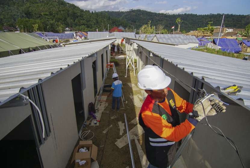 Petugas PLN memasang jaringan listrik di bangunan rumah transisi korban gempa bumi di Desa Kekait, Kecamatan Gunungsari, Lombok Barat, NTB, Jumat (14/9). 