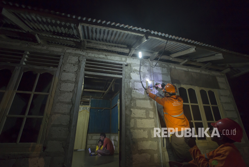 Petugas PLN memeriksa aliran listrik melalui alat meter listrik di salah satu rumah di Desa Lifuleo, Dusun Panaf, Kabupaten Kupang, Nusa Tenggara Timur, Kamis (20/7) malam. 