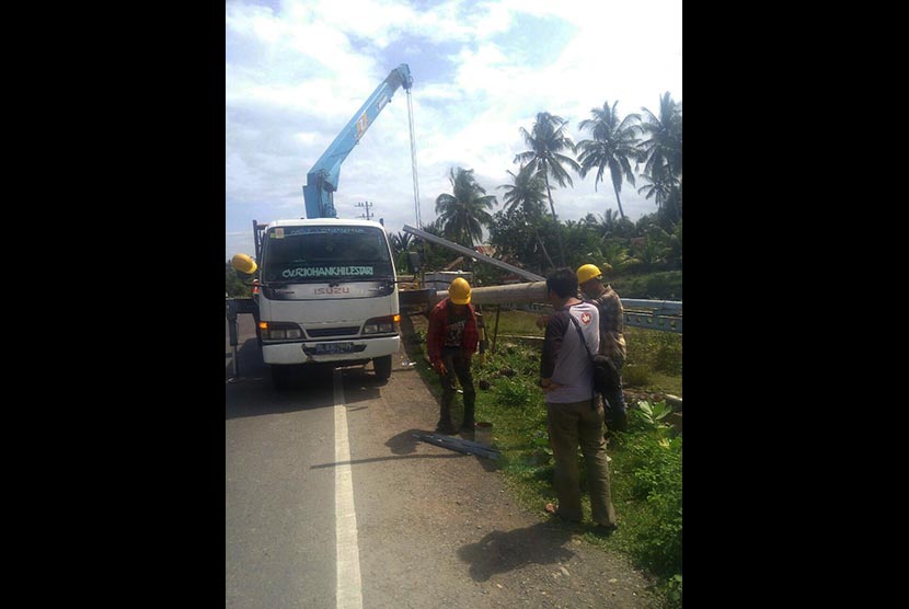 Petugas PLN memperbaiki tiang listrik di wilayah Aceh.