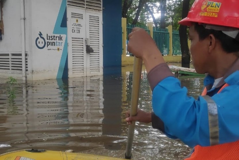 Petugas PLN mengecek gardu listrik yang terendam banjir di wilayah DKI Jakarta, Selasa (25/2) pagi.