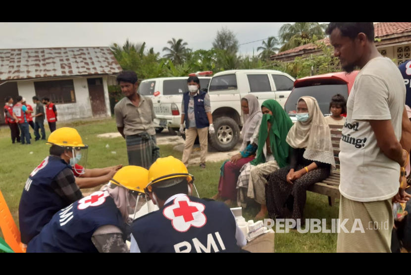 Petugas PMI mendata kesehatan puluhan pengungsi Rohingya yang terdapat di perairan Aceh Utara, Jumat (26/6). 