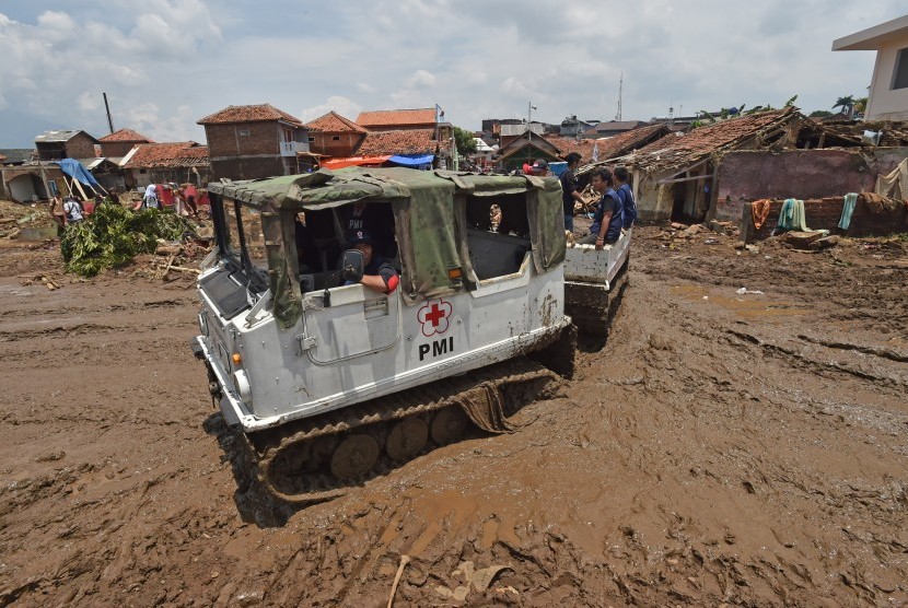 Petugas PMI menggunakan kendaraan Haglund melintasi medan berlumpur di lokasi bencana banjir bandang aliran Sungai Cimanuk di Kampung Cimacan, Tarogong, Kabupaten Garut, Jawa Barat, Jumat (23/9).