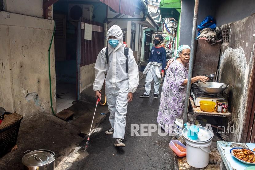 Petugas PMI menyemprotkan cairan disinfektan di area permukiman warga di kawasan Kelurahan Maphar, Jakarta, Kamis (10/2/2022). Penyemprotan disinfektan tersebut untuk mengantisipasi penyebaran virus COVID-19 varian Omicron di lingkungan padat penduduk.