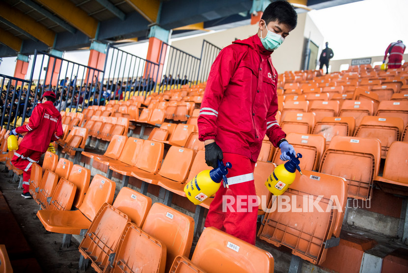 Petugas PMI menyemprotkan cairan disinfektan di bangku penonton sebelum laga Persib Bandung melawan PSS Sleman di stadion Si Jalak Harupat, Kabupaten Bandung, Jawa Barat, Minggu (15/3/2020). 