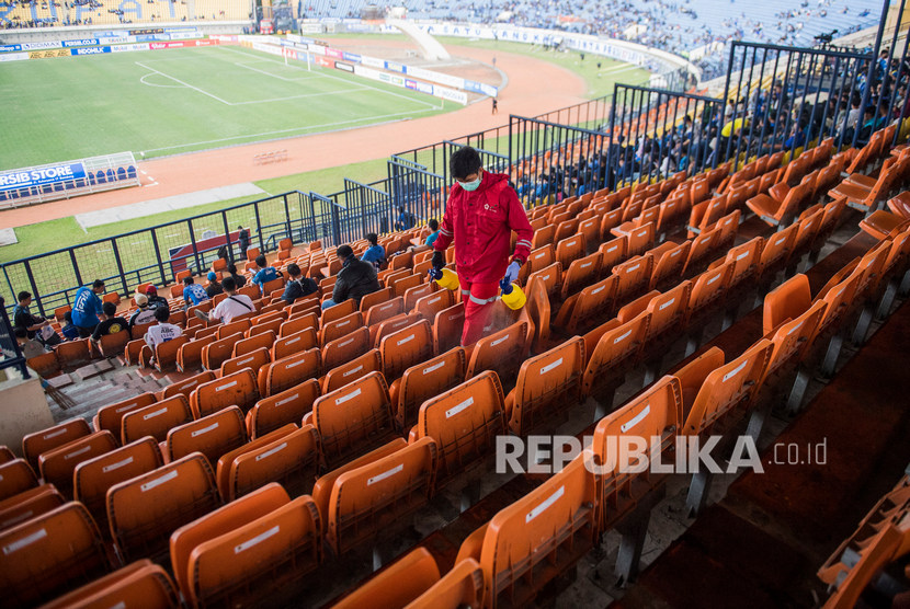 Petugas PMI menyemprotkan cairan disinfektan di bangku penonton sebelum laga Persib Bandung melawan PSS Sleman di stadion Si Jalak Harupat, Kabupaten Bandung, Jawa Barat, Minggu (15/3/2020).(Antara/M Agung Rajasa )