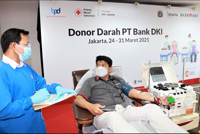 Petugas PMI Provinsi DKI Jakarta (kiri)  mengambil darah dari karyawan Bank DKI ) dalam kegiatan donor darah konvalesen yang dilaksanakan di Kantor Pusat Bank DKI, Jakarta (24/3). Kegiatan donor darah ini dilaksanakan bekerjasama dengan PMI Provinsi DKI Jakarta sebagai rangkaian kegiatan dalam menyambut HUT PT Bank DKI ke-60. 