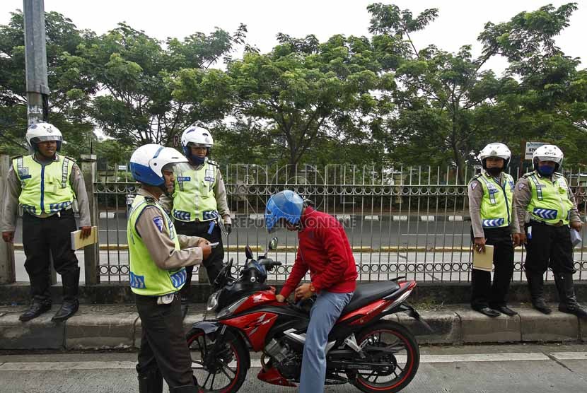 Petugas Polda Metro Jaya merazia kendaraan roda dua yang menerobos masuk ke jalur busway di kawasan Pasar Rumput, Manggarai, Jakarta Selatan, Jumat (22/3).  (Republika/Adhi Wicaksono)