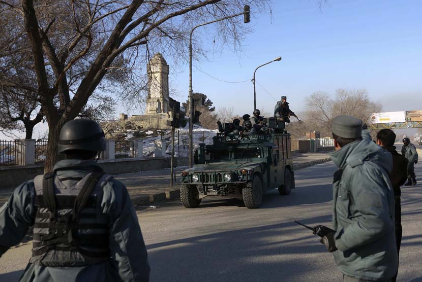   Petugas polisi Afghanistan lari ke markas polisi lalu lintas Kabul setelah diserang oleh gerilyawan di Kabul,Senin (21/1). (Reuters/Omar Sobhani)