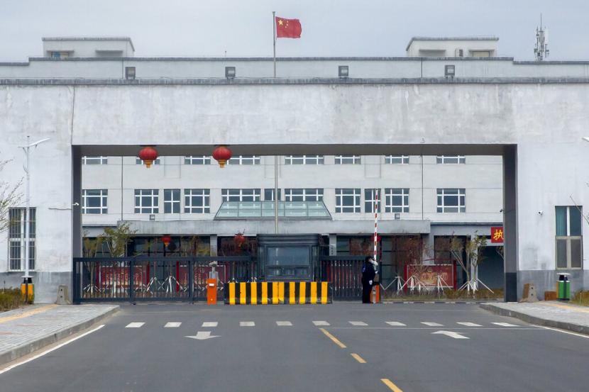 Petugas polisi berdiri di pintu masuk luar Pusat Penahanan Urumqi No. 3 di Dabancheng di Daerah Otonomi Uyghur Xinjiang China barat pada 23 April 2021. Komite Organisasi Perburuhan Internasional (ILO) PBB telah menyerukan misi untuk meninjau lebih lanjut kebijakan perburuhan China di Xinjiang.