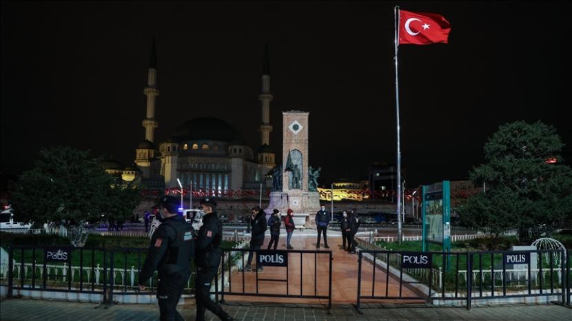 Petugas polisi berpatroli di Lapangan Taksim selama jam malam umum yang diberlakukan mulai Kamis jam 9 malam hingga Senin pukul 5 pagi waktu setempat guna melawan gelombang kedua pandemi Covid-19 selama Malam Tahun Baru, di Istanbul, Turki pada 1 Januari 2021. 