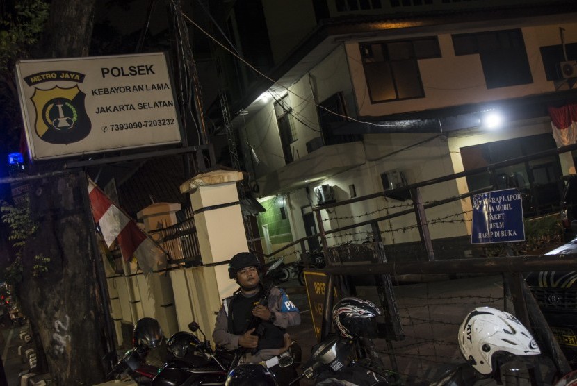 Petugas polisi bersenjata melakukan pengamanan pascapemasangan atribut ISIS di Polsek Kebayoran Lama, Jakarta, Selasa (4/7).