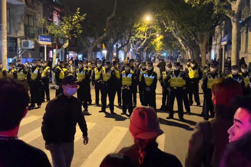  Petugas polisi China memblokir akses ke lokasi tempat para pengunjuk rasa berkumpul di Shanghai pada Ahad, 27 November 2022. Ibu kota China, Beijing, melaporkan 2.086 kasus Covid-19 baru lokal selama 15 jam, Senin (28/11/2022).