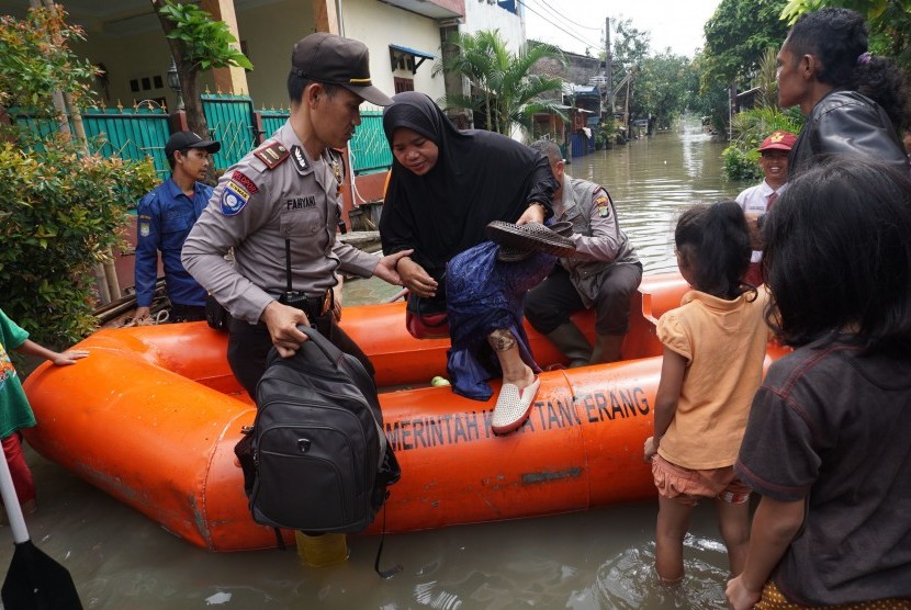 Petugas Polisi dan BPBD Kota Tangerang mengevakuasi warga yang terendam banjir di perumahan Total Persada, Tangerang, Banten.