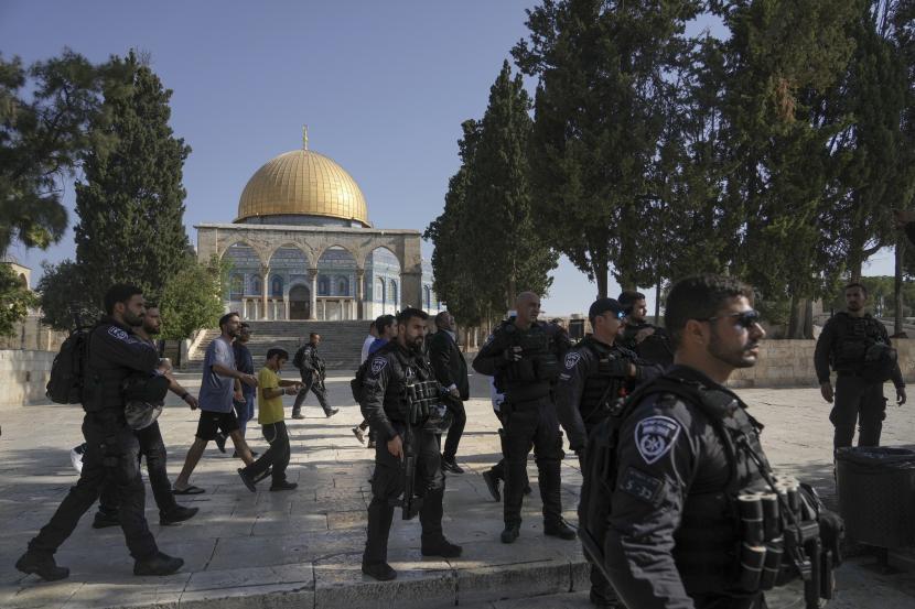 Petugas polisi Israel mengawal sekelompok pria Yahudi mengunjungi Temple Mount, yang dikenal oleh umat Islam sebagai Tempat Suci, di kompleks Masjid Al-Aqsa di Kota Tua Yerusalem, selama ritual berkabung tahunan Tisha BAv (kesembilan dari Av) hari puasa dan hari peringatan, memperingati penghancuran kuil kuno Yerusalem, Ahad, 7 Agustus 2022. Arab Saudi: Serbuan Pemukim Israel ke Masjid Al Aqsa Pelanggaran Berat