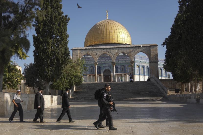 Petugas polisi Israel mengawal sekelompok pria Yahudi untuk mengunjungi Temple Mount, yang dikenal oleh umat Islam sebagai Suaka Mulia, di kompleks Masjid Al Aqsa di Kota Tua Yerusalem, selama ritual berkabung tahunan Tisha BAv (kesembilan of Av) hari puasa dan hari peringatan, memperingati penghancuran kuil kuno Yerusalem, Ahad, 7 Agustus 2022. 