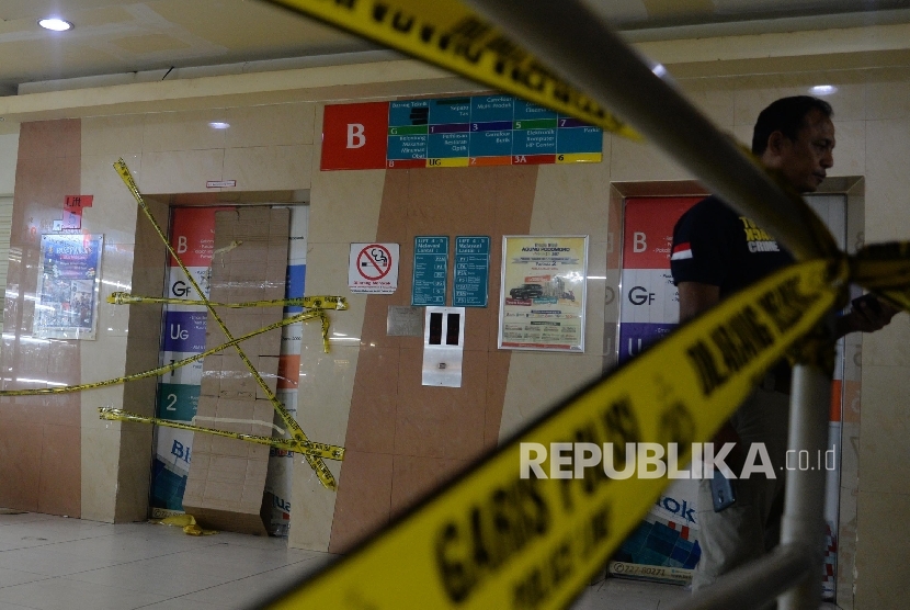 Petugas polisi melakukan identifikasi lokasi terjatuhnya lift di lantai basement Blok M Square, Jakarta, Jumat (17/3). 